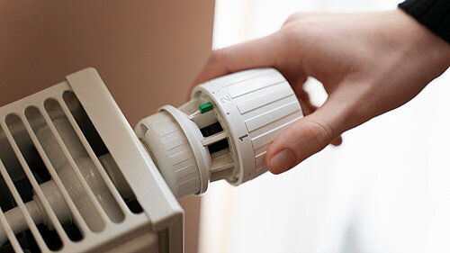Person adjusting a radiator